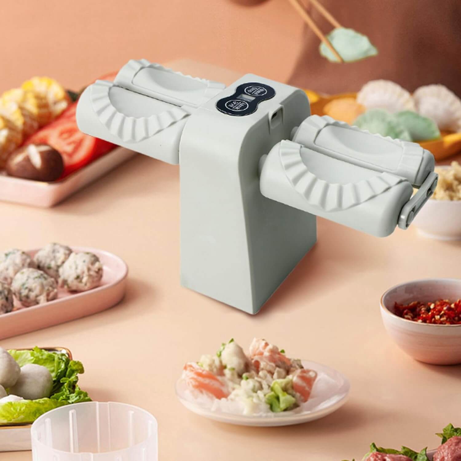 The dumpling maker machine on a table surrounded by food and condiments.