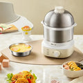 The electric egg cooker on a table surrounded by various foods.