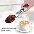 The electronic measuring spoon measuring coffee. A ready made coffee in the corner.