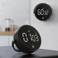 The magnetic digital kitchen timer magnetically mounted on a wall and one resting on a desk using its bracket.